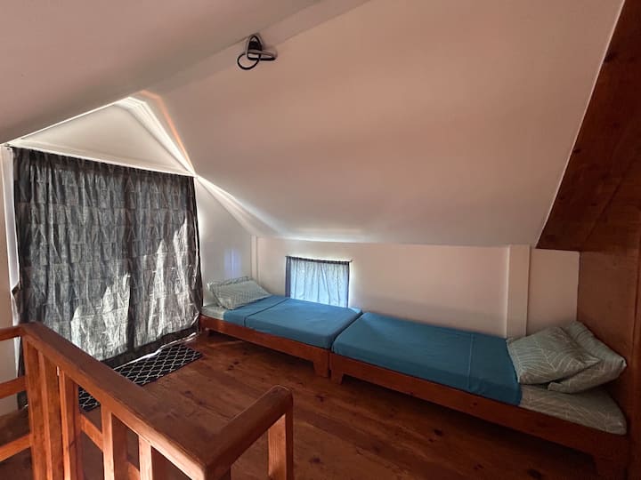 loft bedroom with 2 single beds and a balcony