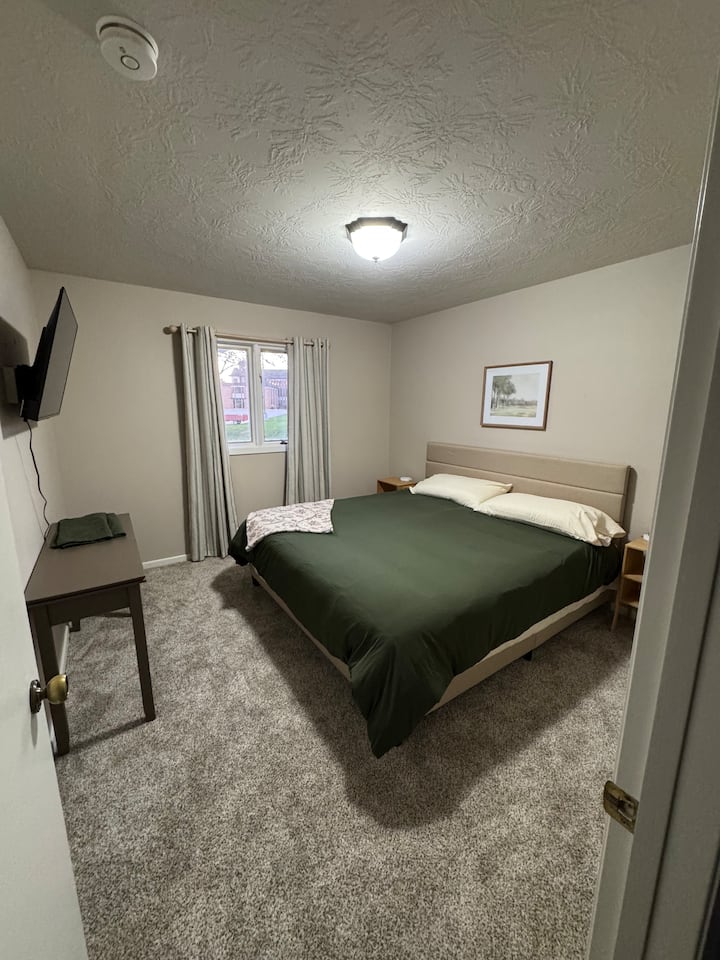 Cama tamaño king con área de armario, acceso al cargador de teléfono y TV inteligente de 43 pulgadas. 