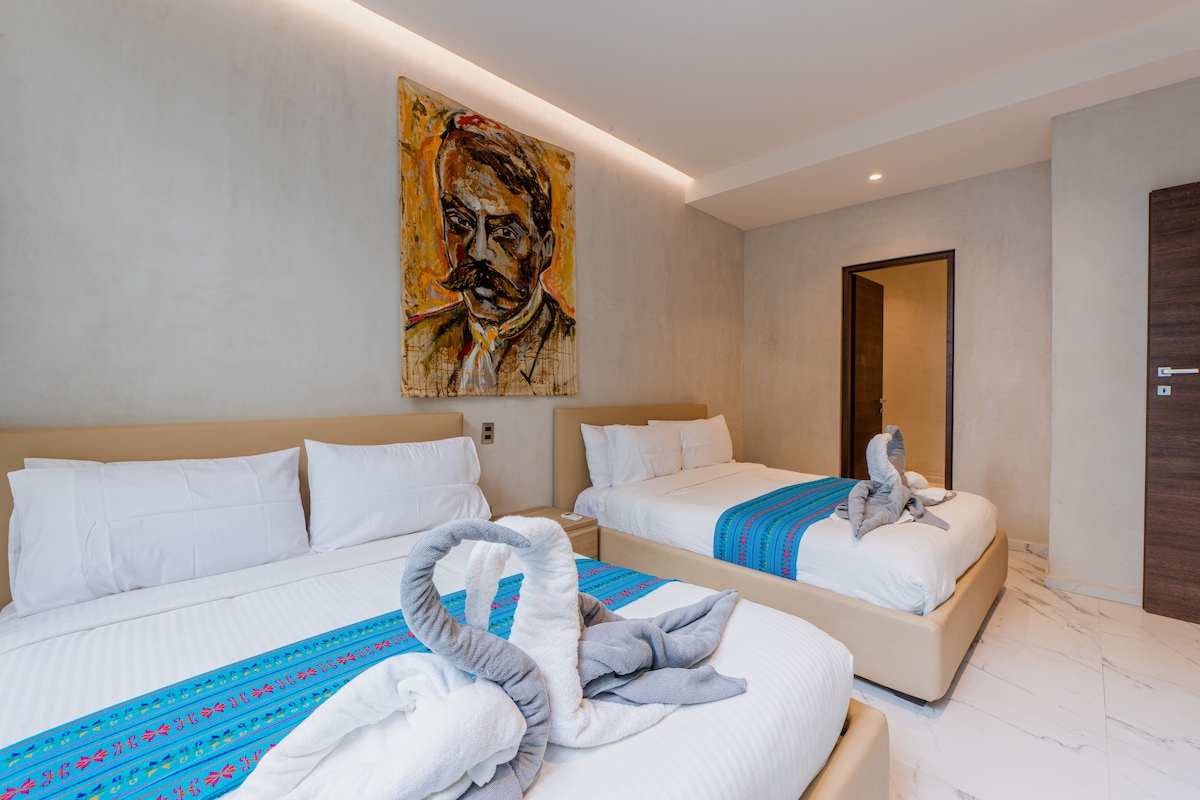 Amplio dormitorio con dos camas tamaño matrimonial.