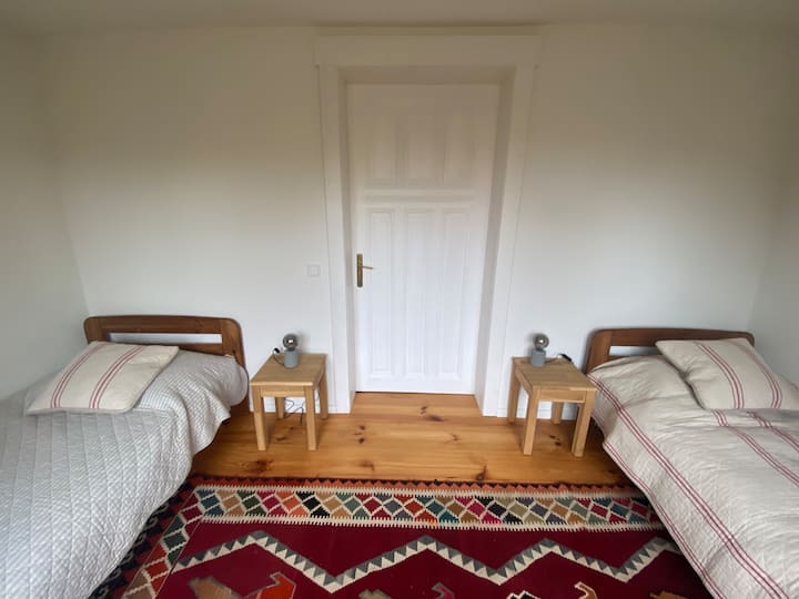 Schlafzimmer 2 im Erdgeschoss mit 2 Einzelbetten und Zugang zum Wohn-Essbereich.