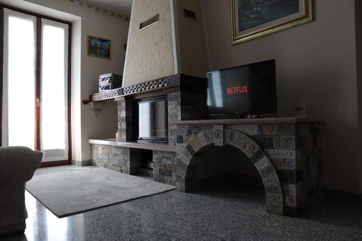 Kutak dnevnog boravka s neupotrebljivim kaminom, 4K HD pametnim televizorom i radijem s radnim sanducima.