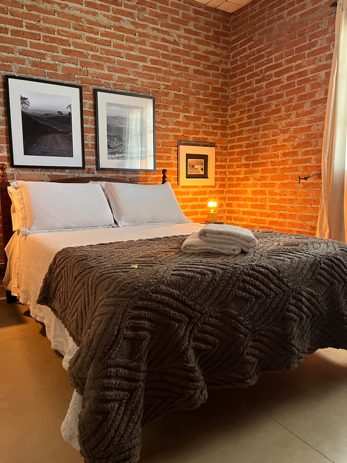 Quarto com parede de tijolos da Unidade 1
