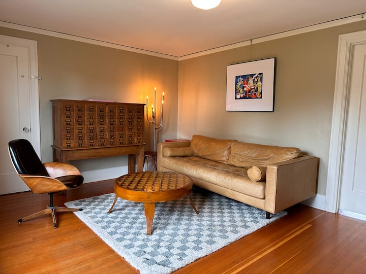 Esta sala de estar está justo fuera del dormitorio principal. El sofá es del tamaño de un colchón individual y podría acomodar a un huésped para que duerma.