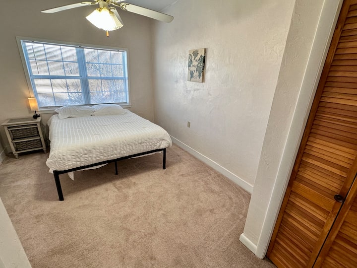 Bračni krevet (160x200) sa stolom i svjetiljkom. Pogled s vrata 