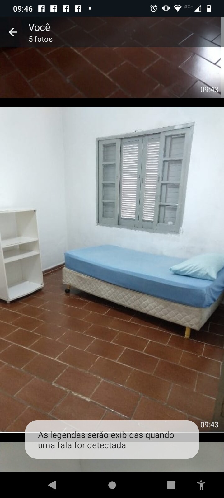 A modest sleeping area features a single bed with a light blue mattress. A small white shelf stands against the wall, providing storage space. Natural light enters through a window with gray shutters, illuminating the room's tiled floor.