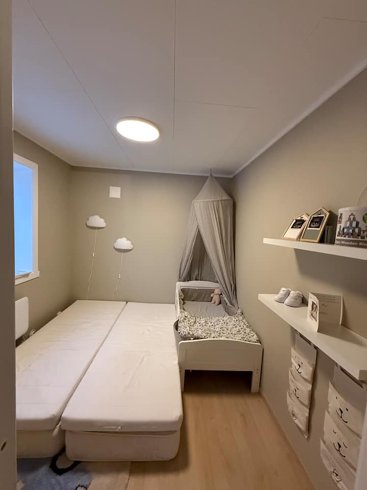 חדר ילדים עם מזרן זוגי ומיטת ג'וניור. יש ספרים לילדים.