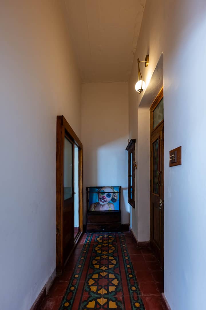 La pasarela hacia tu suite Kashish: azulejos vibrantes bajo los pies, un toque de arte por delante y un carácter vintage por todas partes.