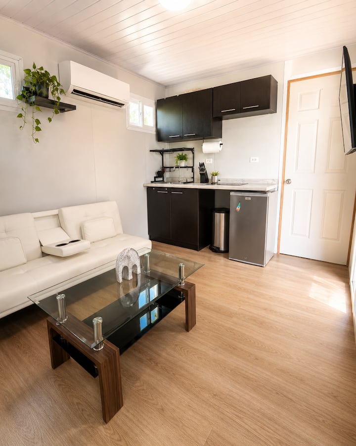 Espacio integrado de sala y cocina, equipado para una estancia cómoda, con aire acondicionado y buena iluminación natural.