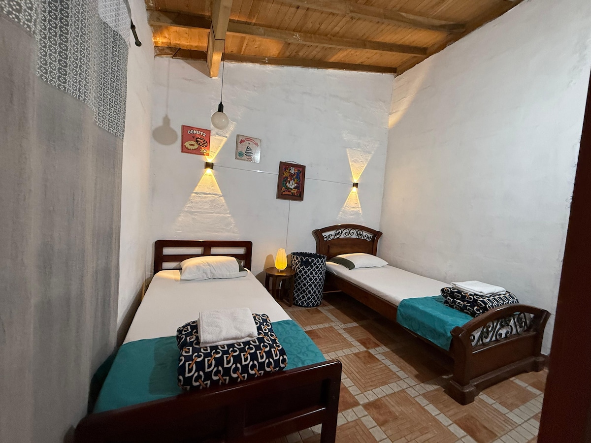 La habitación #3 cuenta con 2 camas sencillas y está dentro de la cabaña principal.

Cuidadosamente ambientada y decorada con iluminación blanca y cálida, sábanas suaves y mantas.

Está comunicada con la habitación #4 