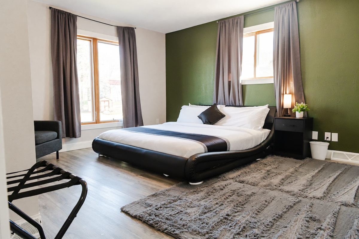 1张加大双人床，配有坐椅和行李架。