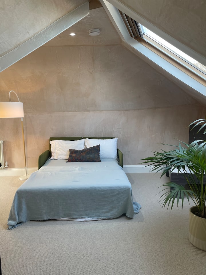 Cómodo sofá cama doble en loft luminoso y privado con espacio de trabajo. 