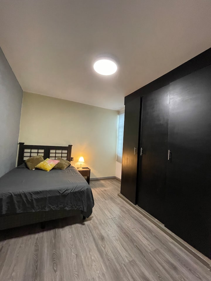 Recámara 2 cuenta con cama queen size, ventilador, silla y clóset.