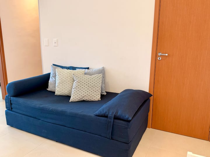 O sofá-cama da sala pode acomodar uma pessoa para dormir.