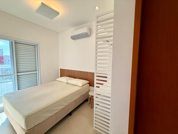 Suíte aconchegante com cama de casal, ar-condicionado e armário aberto com prateleiras e cabides.
Ideal para pessoas que buscam conforto e praticidade durante a estadia.