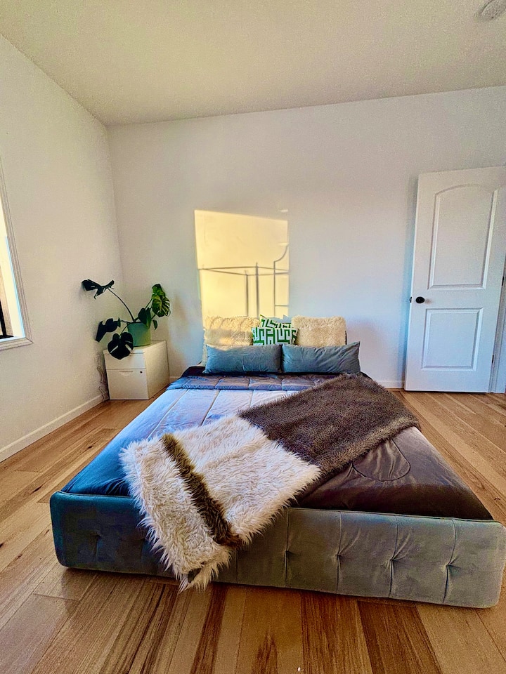 Მთავარი საძინებელი დედოფლის ზომის მეხსიერების ქაფის მატრასით. Თაღის ხედი კოქტეილების აუზს გადაჰყურებს. 