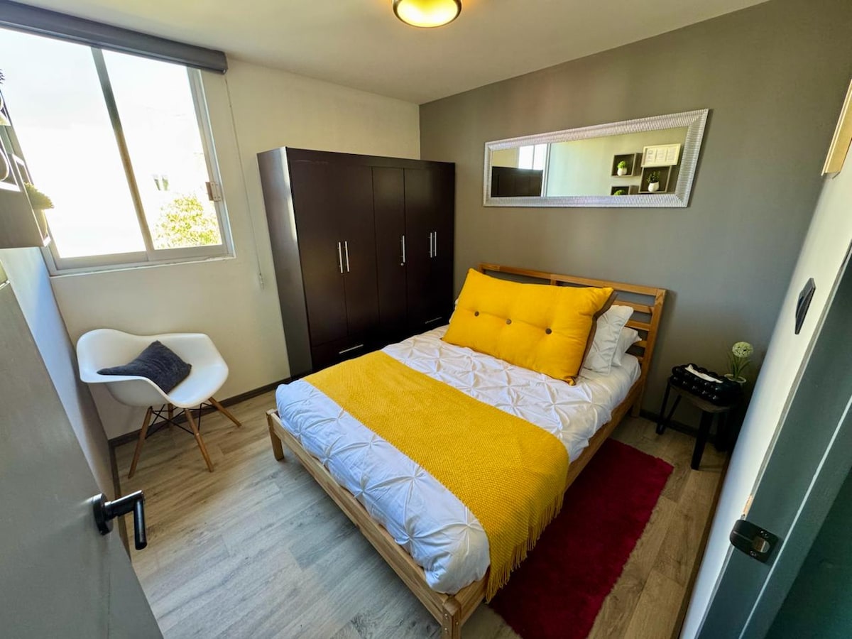 Svijetla i dobro opremljena soba s bračnim krevetom, prostranim ormarom, ergonomskom stolicom i roletama za privatnost. Idealno za duži boravak u udobnosti i stilu.