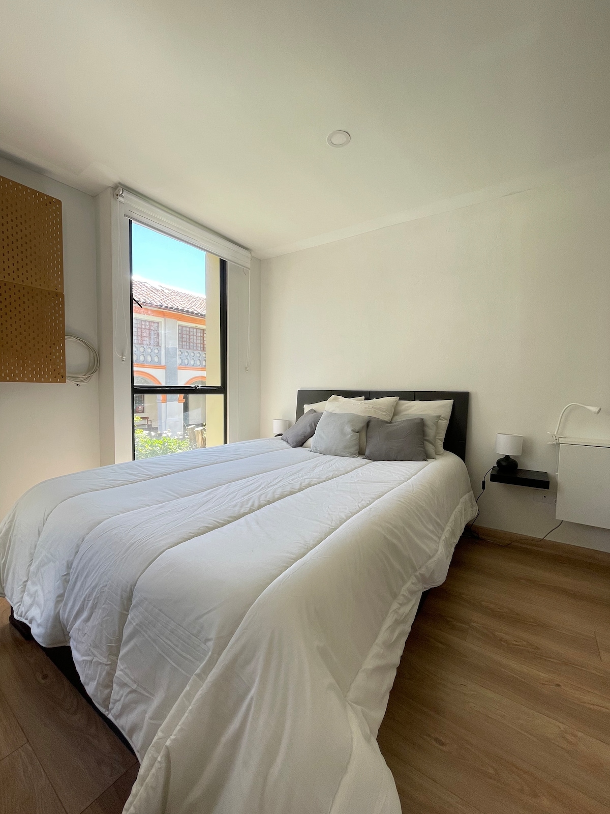 Спална соба со двоен кревет, добро природно осветлување, мека постелнина и ноќни масички. Удобен простор за одмор.