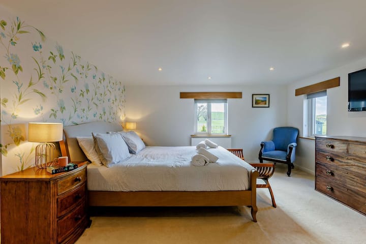 Ferma Waterland - dhoma kryesore e gjumit. me një krevat super king, televizor, dhomë dushi en suite dhe një shëtitje në gardërobë.