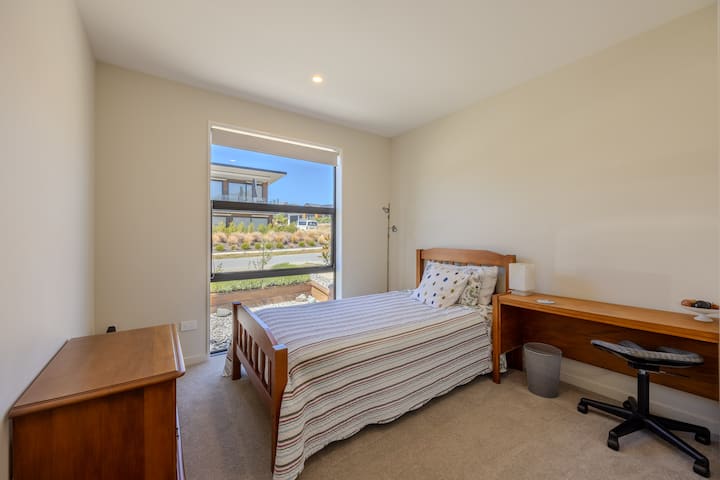 חדר עם מיטת יחיד, שולחן כתיבה, ארון וחלל תלייה 