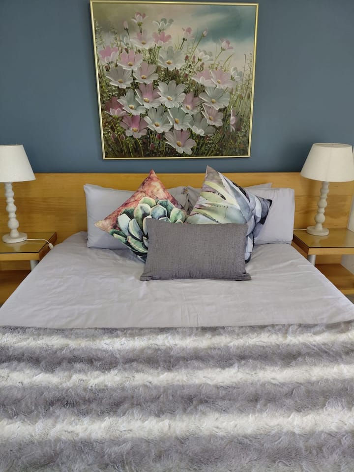 นอนหลับสบายบนเตียงควีนไซส์ในห้องนอนหลัก มีตู้เสื้อผ้าและกระจกขนาดใหญ่ 