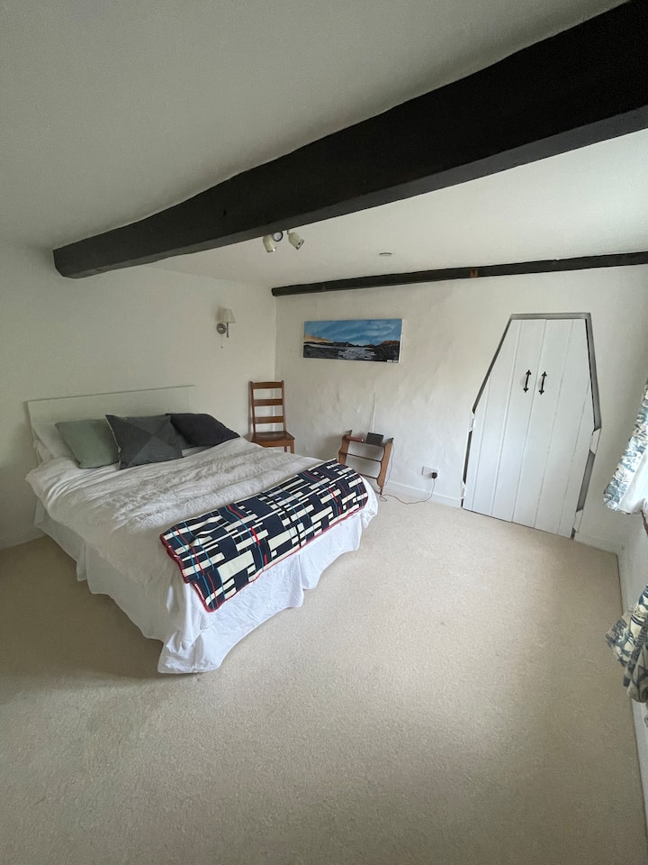 Očarujúca spálňa v chalupke s výhľadom na záhradu a vidiek.