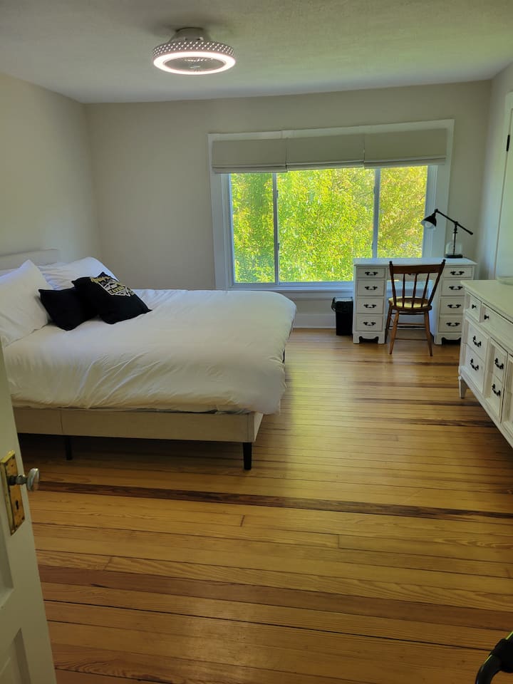 This spacious 2nd floor bedroom features a king-size bed, dresser, and two closets for ample storage. Desk is perfect for video calls while away. Unwind with a 40” smart TV, all in a stylish, comfortable retreat designed for work and relaxation.