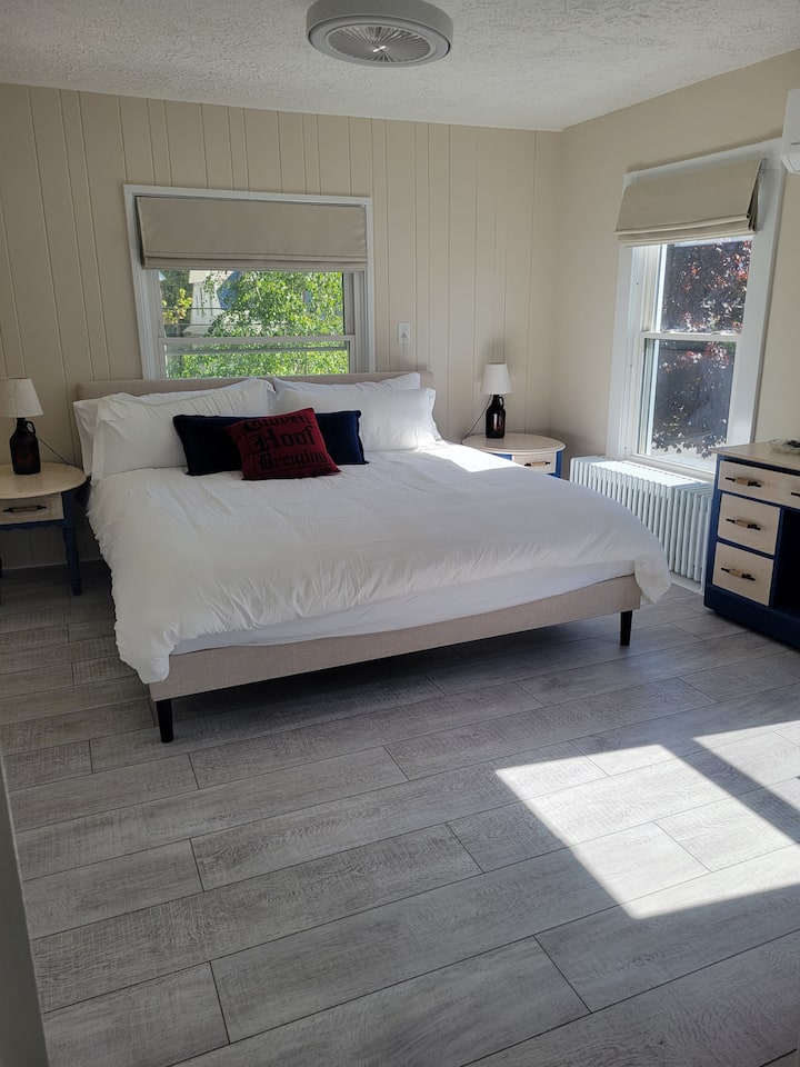 This cozy 2nd floor bedroom features a luxurious king-size bed, two small dressers and a luggage rack for ample storage. Unwind with a 40” smart TV, all in a stylish, comfortable retreat. This is the 3rd king size bed in the home. 