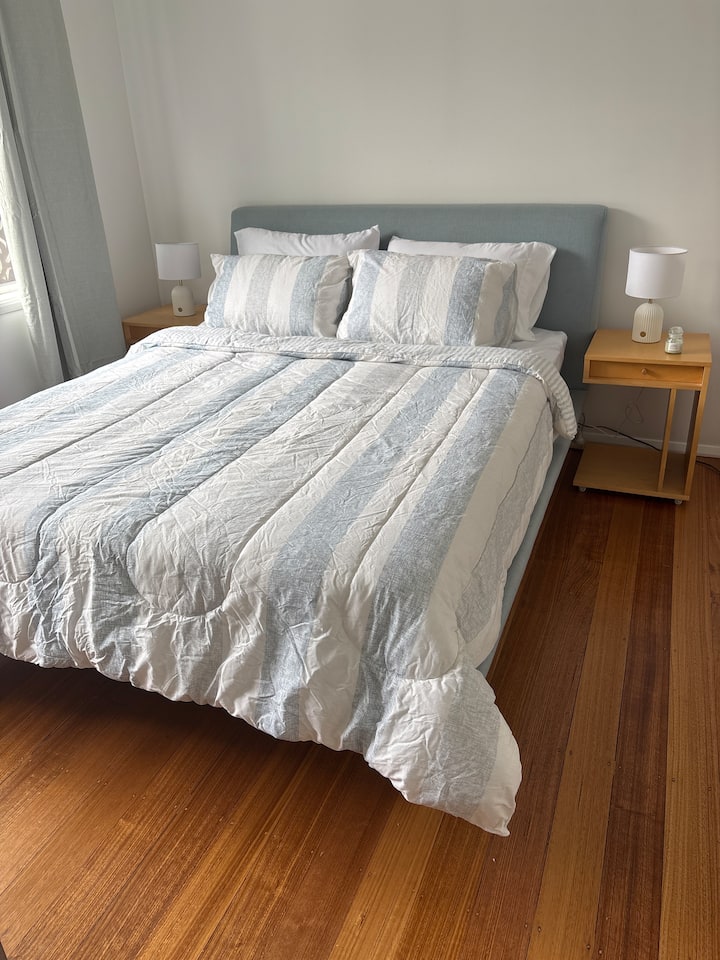 Удобно двойно легло с странични маси, лампи и отворен гардероб. Тази стая е достатъчно голяма, за да побере детско креватче или легло, разположено под леглата