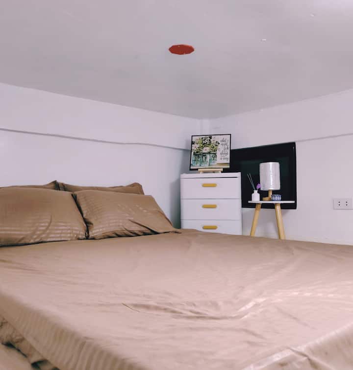 Este acogedor dormitorio cuenta con una cómoda cama tamaño Queen. A un lado de la cama, se encuentra una elegante mesa de lámpara con una moderna lámpara de mesa. La habitación está decorada tanto para la comodidad como para el estilo, con tonos neutros y detalles sutiles, lo que proporciona un retiro sereno.