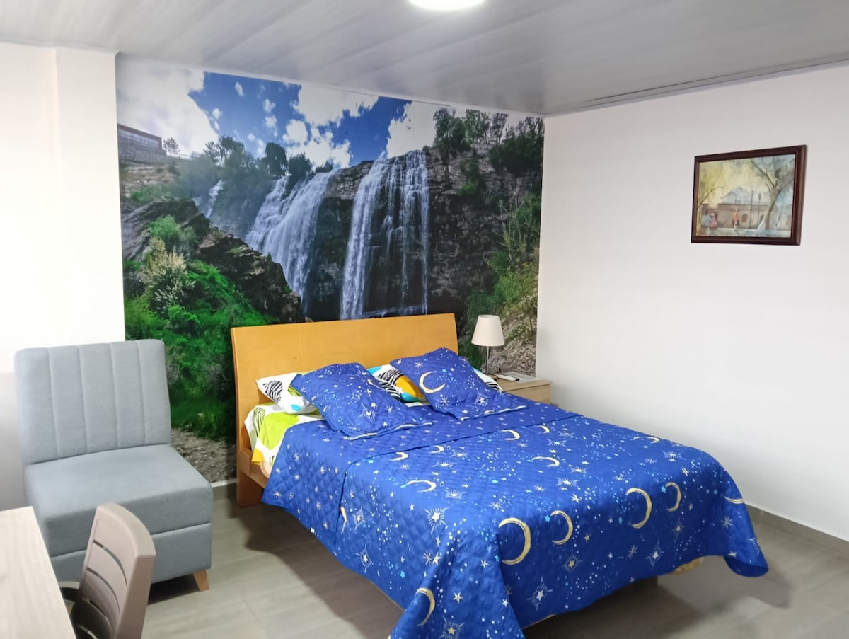 Habitación principal amplia y luminosa, con cama doble, clóset, escritorio, Smart TV y antena DirectTV. Baño privado con ducha de agua caliente. Ideal para descansar o trabajar con total comodidad.