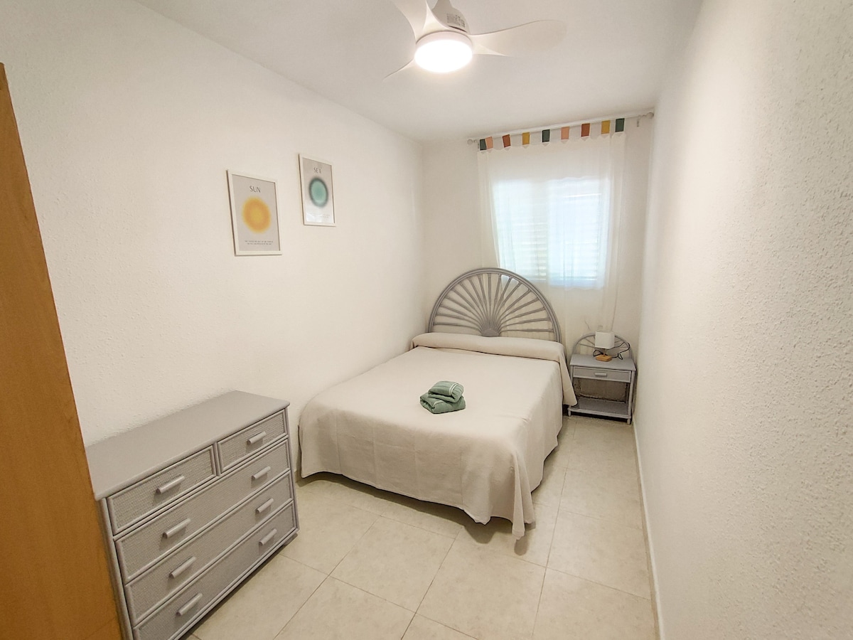 غرفة نوم بسرير مزدوج 135 سم ومروحة سقف. تحتوي على خزانة كبيرة ومنضدة مريحة.