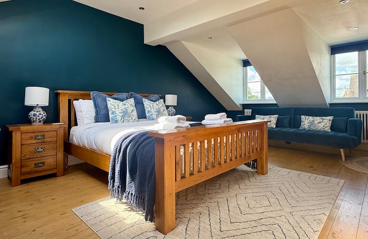 ห้องนอนลอฟท์กว้างขวางพร้อมเตียงคิงไซส์ เตียงโซฟา และหน้าต่างที่มีเสน่ห์ เหมาะสำหรับคู่รัก ครอบครัว หรือผู้ที่ต้องการพื้นที่เพิ่มเติม