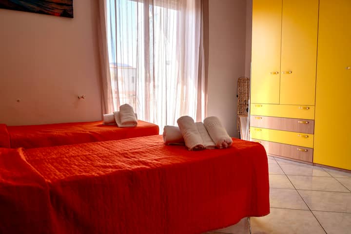 Bedroom with two comfortable single beds and a closet for your clothes.
Thanks to the large window door, the room is very bright and sunny.