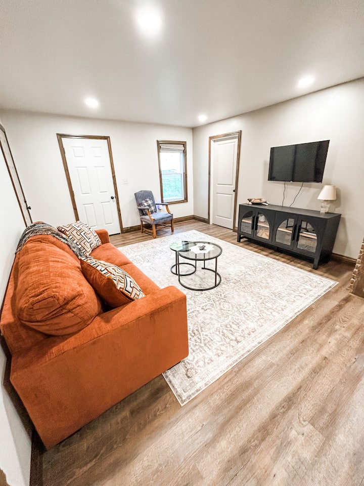 Relájate en la acogedora sala de estar, con asientos lujosos y una Smart TV. Creekside Haven.