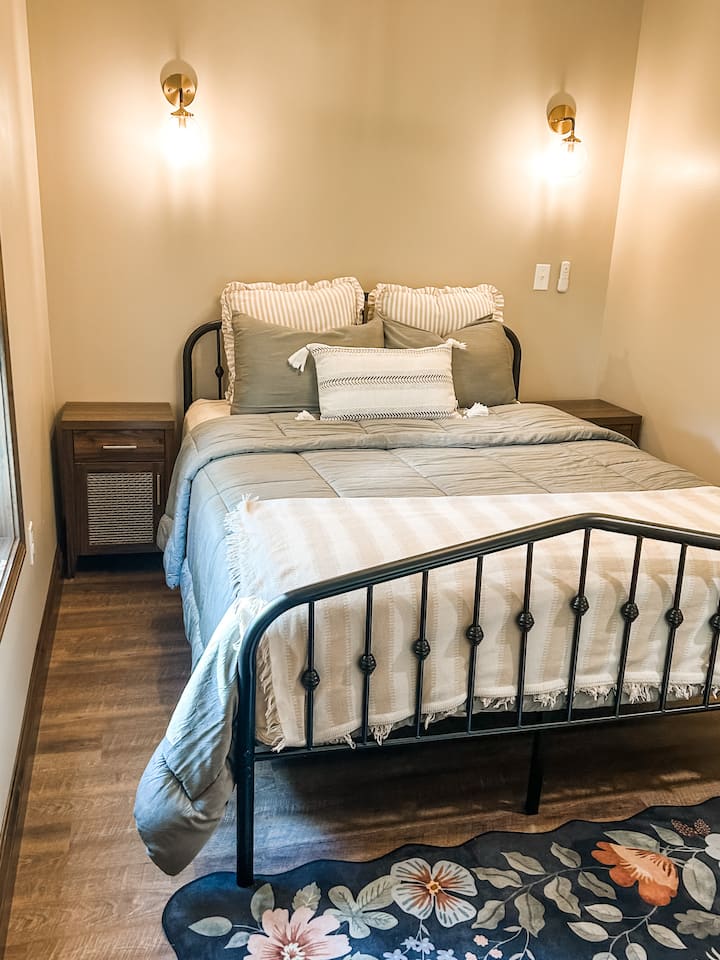 Acomódate en el dormitorio privado con cama tamaño queen, sábanas suaves y un entorno tranquilo.