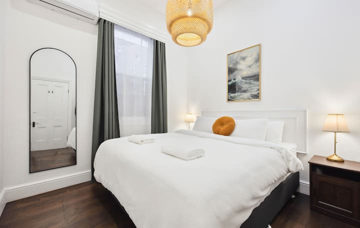 Bedroom 2 features a luxurious king-sized bed with premium linen, reverse cycle air-conditioning, a clothes rack, block-out curtains and soft lighting with a dimmer switches. 