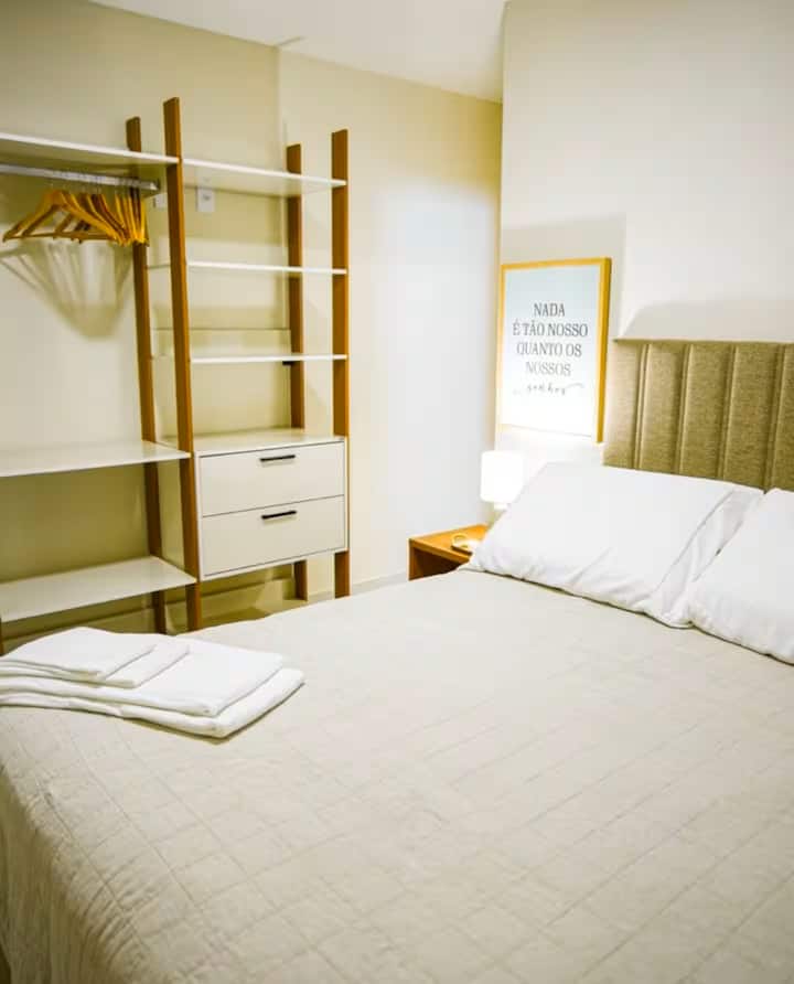 Quarto 1 equipado com cama de casal, ar-condicionado, local para guardar as roupas, cabides, cobertores e travesseiros extras e cortinas blackout.