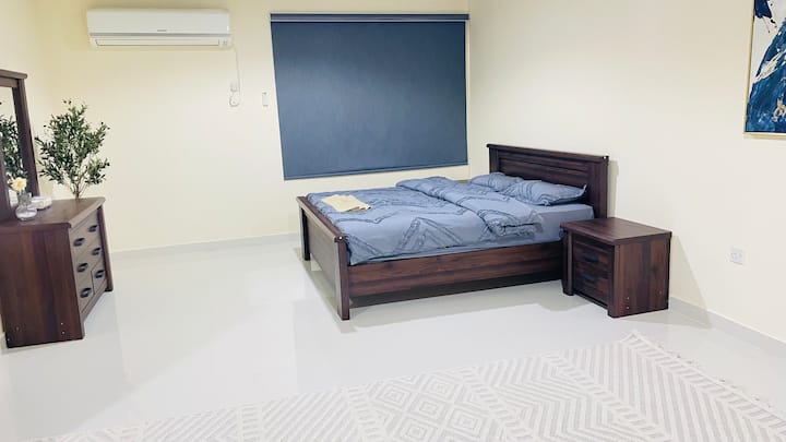 Amplia habitación con cama tamaño king y sofá, armario y baño privado