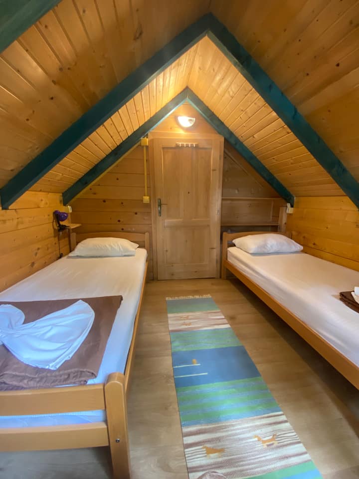 spálňa na prvom poschodí s dvoma samostatnými posteľami, komodou a poličkou na šatník