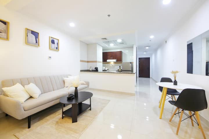 Relájate en la sala de estar, donde un sofá, una mesa de centro y un televisor crean una configuración acogedora para el tiempo de inactividad y las noches informales. El diseño abierto del estudio y los pisos luminosos te dan espacio para relajarte, moverte libremente y acomodarte cómodamente.