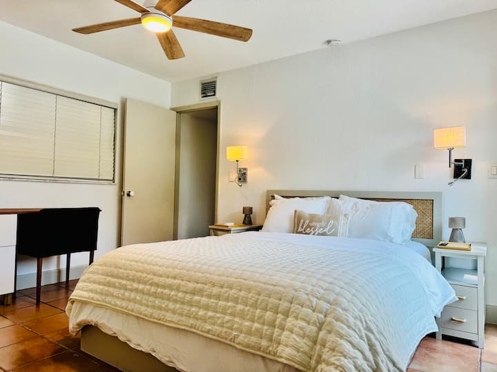 Fräscha vita bomullslakan på bekväm dubbelsäng och bekväm arbetsyta.