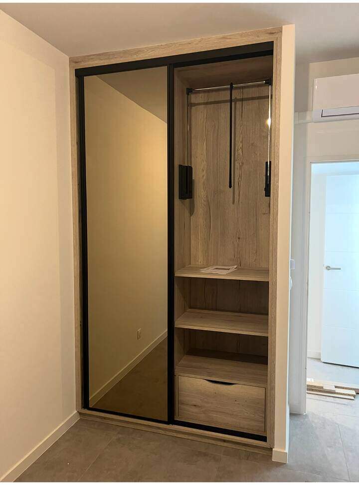 DRESSING DOUBLE : PORTES COULISSANTES AVEC MIROIR, PENDERIES INTEGREE AVEC POIGNEE, CINTRES.