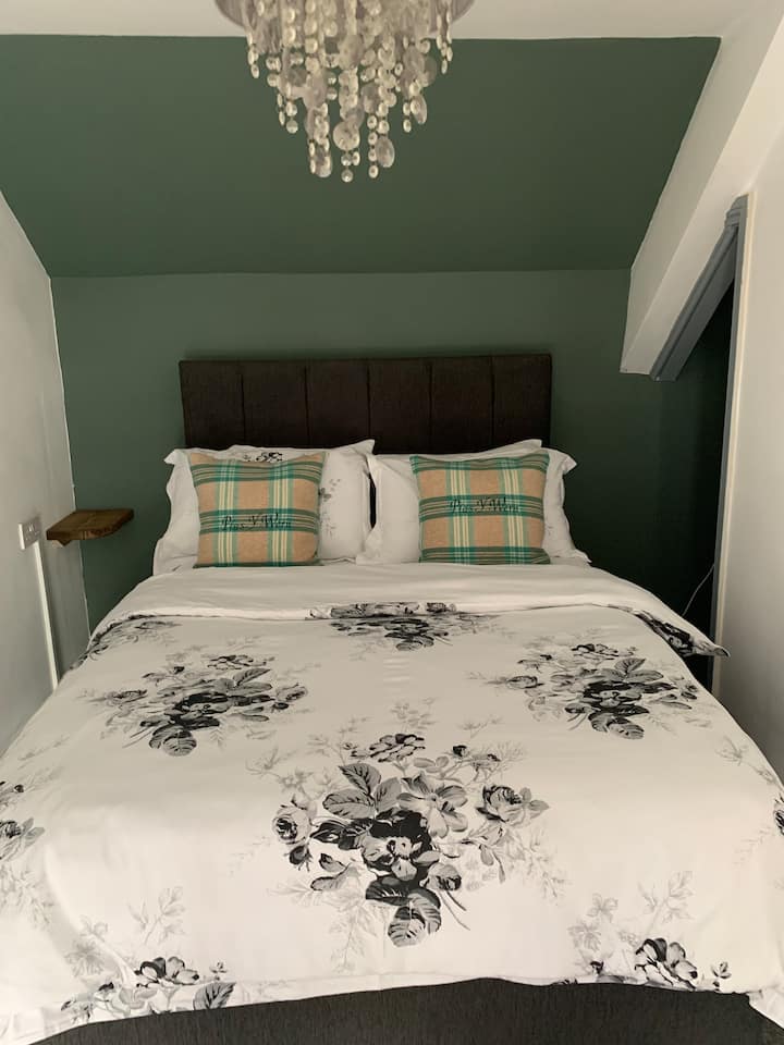 A cozy double with a small dressing area, chair, side shelving with lamp, and charging points. A freestanding rail is provided for clothes.  I always use nice bedding such as Dorma & Laura Ashley This bedroom also leads directly into Bedroom 3.