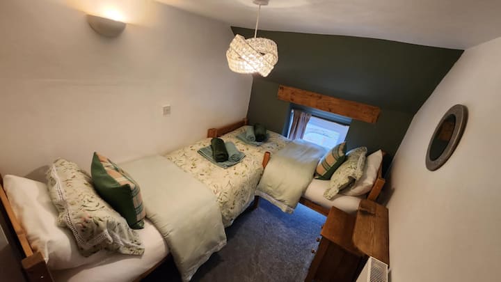 Located off Bedroom 2, this room features two single beds, a dressing table, and a fitted wardrobe for clothes. Guests enjoy high-quality 300-thread-count linen, soft towels, and cozy throws for cooler evenings—perfect for the bed or the garden.