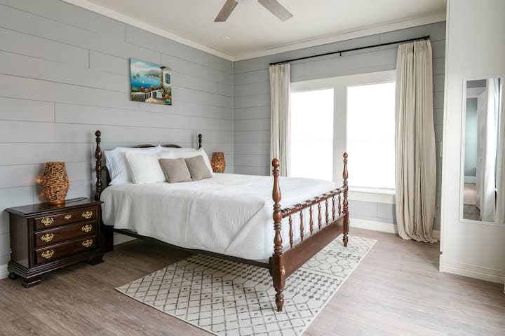 Este segundo dormitorio cuenta con una cómoda cama tamaño queen, dos mesitas de noche con enchufes y puertos USB para una fácil carga. Las persianas oscurecidas garantizan un sueño reparador y el armario incluye perchas, sábanas y toallas adicionales.