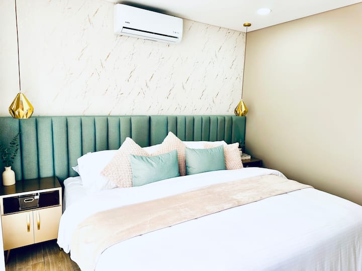 Главна соба со електрични завеси, клима уред, телевизор и балкон со маса и столови за уживање во прекрасните зајдисонца.