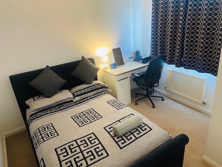 Светла двойна спалня с удобно двойно легло, удобно бюро и чайник в стаята с безплатен чай и кафе – идеално за отдих или работа в комфорт.