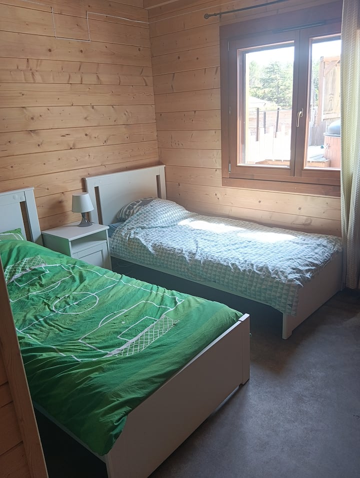 2 lits simples avec table de chevet.