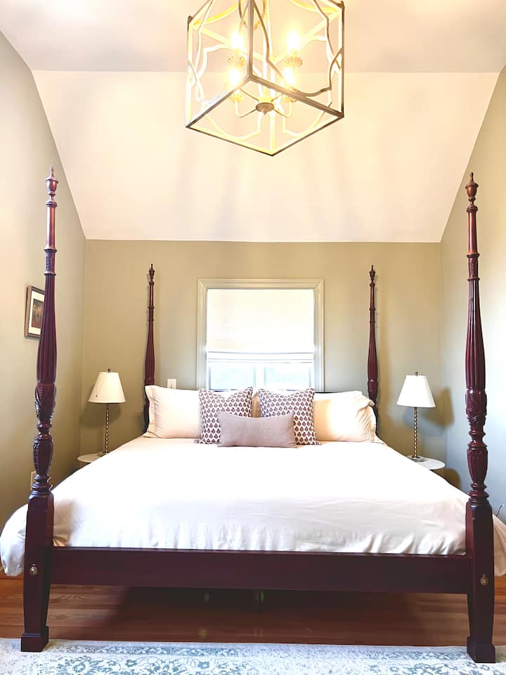 La 2e chambre principale Sage de la suite/appartement se trouve de l'autre côté de la maison avec ses propres logements privés.  La chambre dispose d'un haut plafond avec lit en bois à baldaquin, d'une chaise longue et d'une commode pour le rangement. 