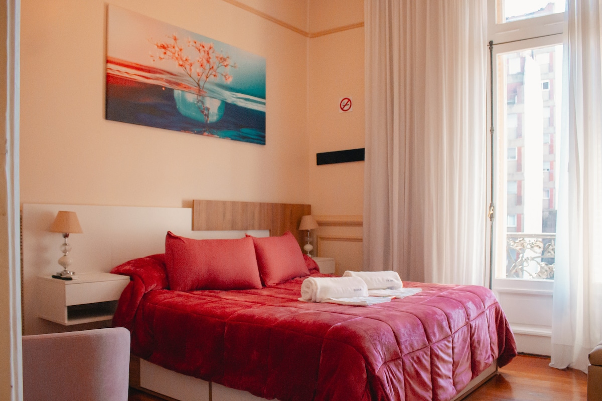 Dormitorio principal con Balcón. Cama King Size y almohadas premium, Tv 43, calefacción, frio/calor. Baño completo en suite. Mesa  con sillones y desayuno en habitación. 